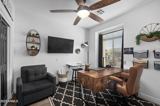 home office with a ceiling fan, baseboards, visible vents, and wood finished floors