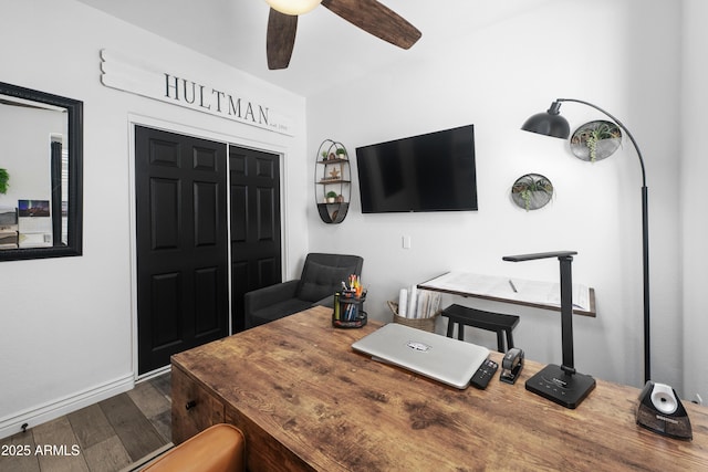 home office featuring a ceiling fan, baseboards, and dark wood-type flooring