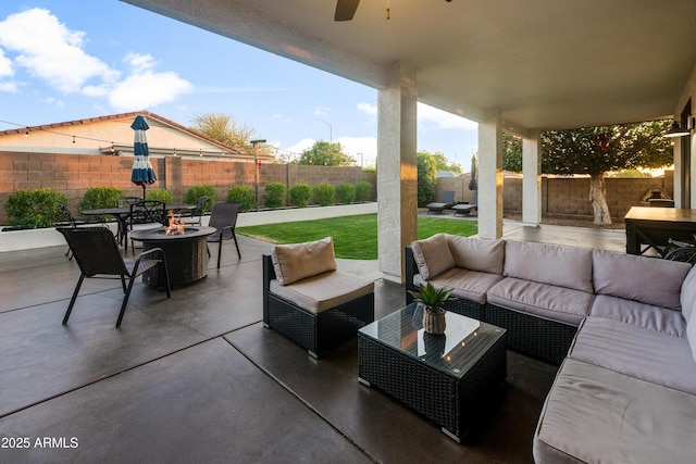 view of patio with a fenced backyard, an outdoor living space with a fire pit, and ceiling fan