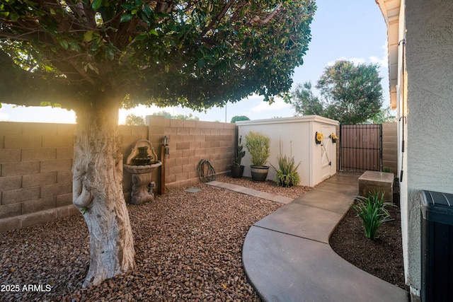 view of yard with a fenced backyard and a gate