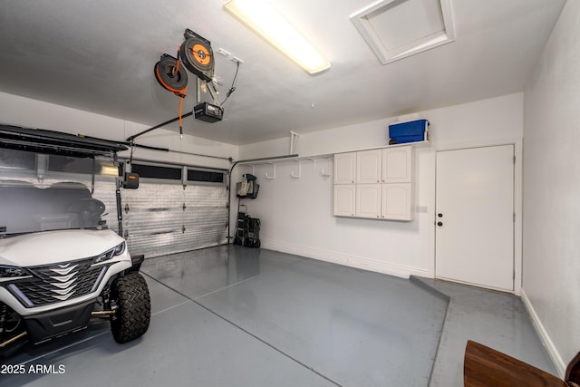 garage with baseboards and a garage door opener