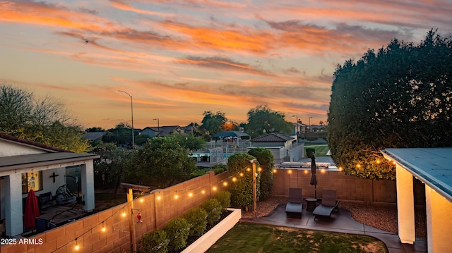 view of yard featuring a fenced backyard, a patio area, and a residential view