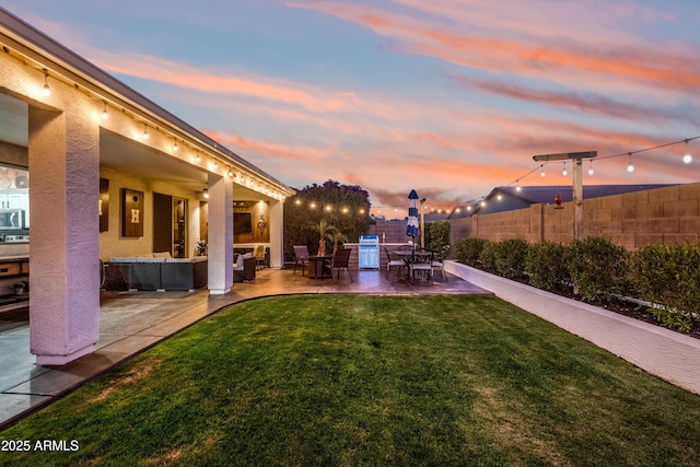yard at dusk with fence, a patio, and outdoor lounge area