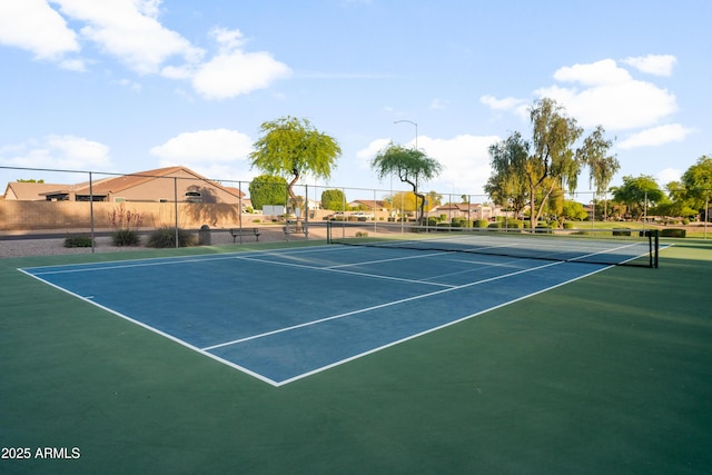 view of tennis court featuring community basketball court and fence