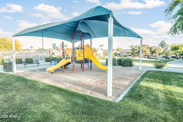 community jungle gym featuring fence and a yard