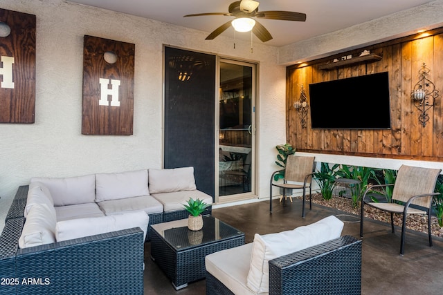 living room featuring a textured wall, ceiling fan, and finished concrete flooring