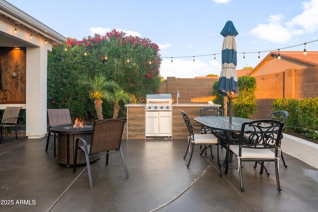 view of patio with fence, outdoor dining space, an outdoor fire pit, and area for grilling