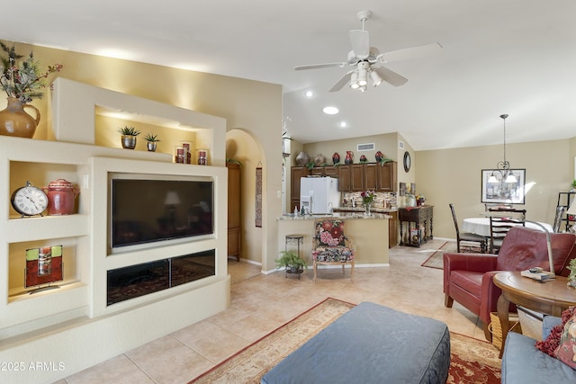 living room featuring light tile patterned floors and ceiling fan with notable chandelier