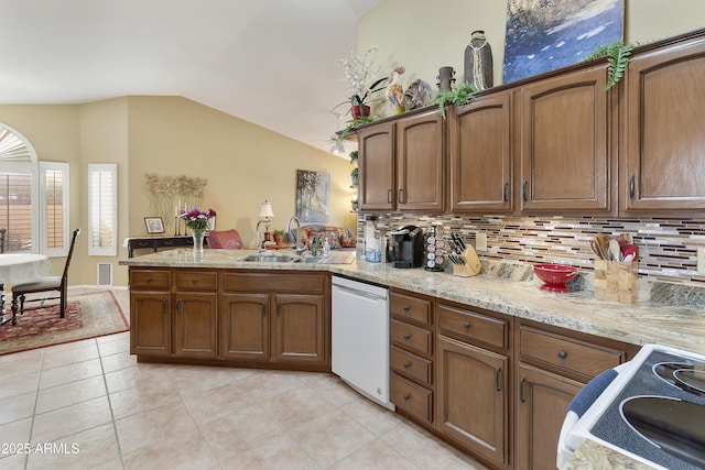 kitchen featuring tasteful backsplash, white dishwasher, vaulted ceiling, sink, and range