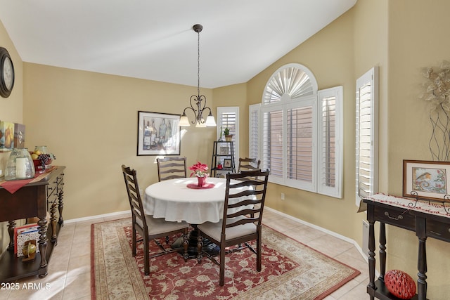 dining room featuring light tile patterned flooring, a chandelier, and lofted ceiling