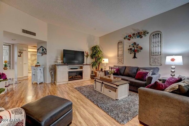 living room with light hardwood / wood-style flooring and a textured ceiling