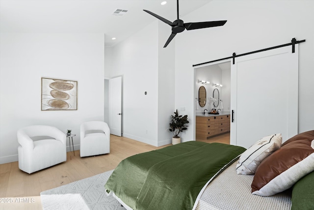 6329 N 10th Dr, Phoenix, AZ 85013 - bedroom with a barn door, high vaulted ceiling, visible vents, and light wood finished floors