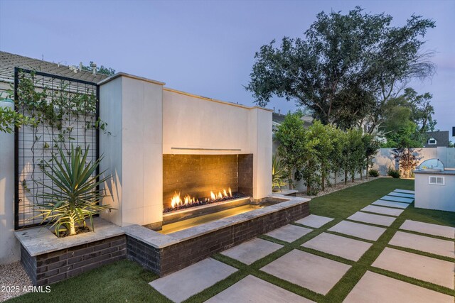 6329 N 10th Dr, Phoenix, AZ 85013 - view of yard featuring an outdoor brick fireplace, fence, and a patio area