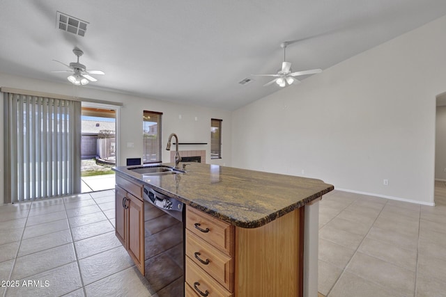 kitchen featuring sink, vaulted ceiling, dark stone countertops, black dishwasher, and a kitchen island with sink