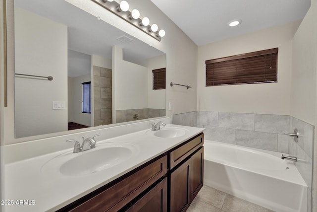 bathroom with vanity, a washtub, and tile patterned floors