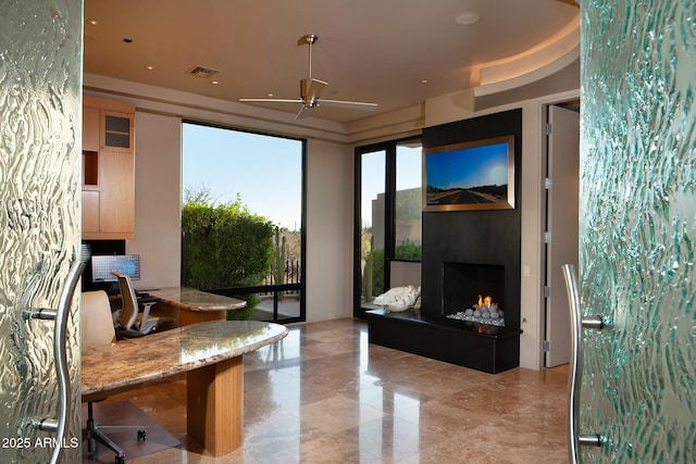 office space featuring ceiling fan and exterior fireplace