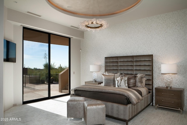 bedroom featuring a raised ceiling and access to outside