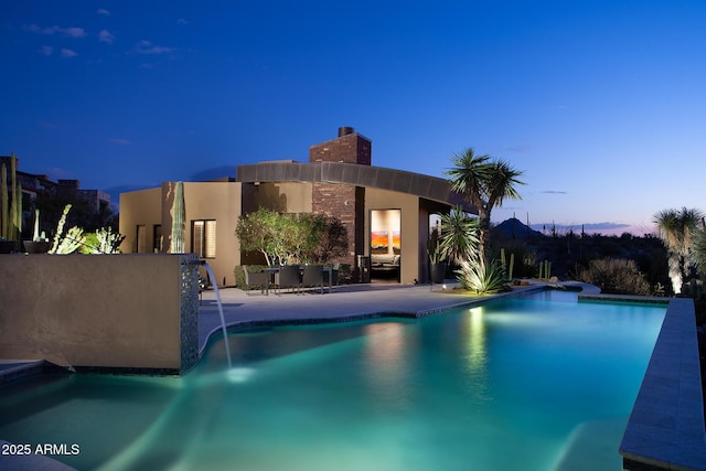 pool at dusk with a patio