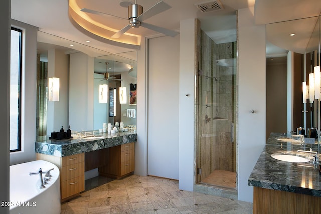 bathroom with plus walk in shower, vanity, and ceiling fan