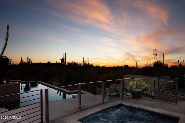 pool at dusk with a patio area