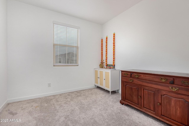 bedroom featuring light colored carpet and baseboards