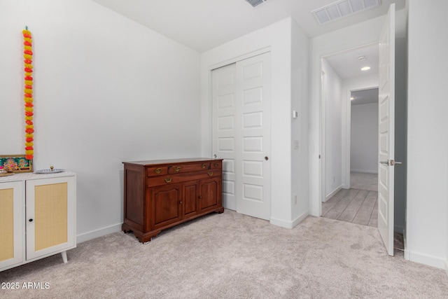 bedroom featuring light carpet, visible vents, and baseboards