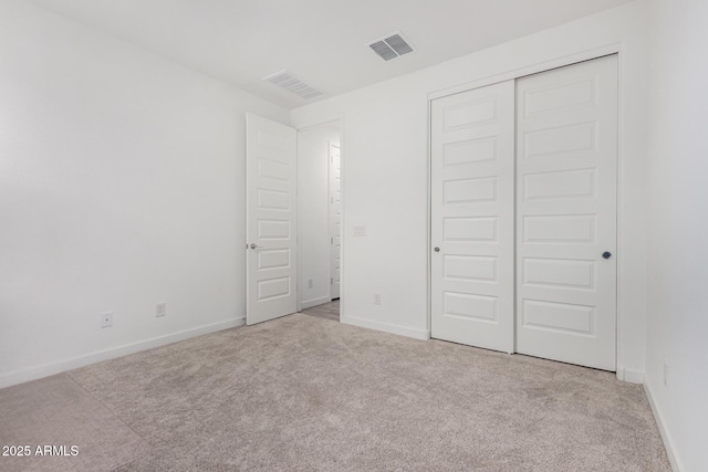 unfurnished bedroom featuring baseboards, carpet, visible vents, and a closet