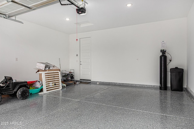 garage with a garage door opener, recessed lighting, and baseboards