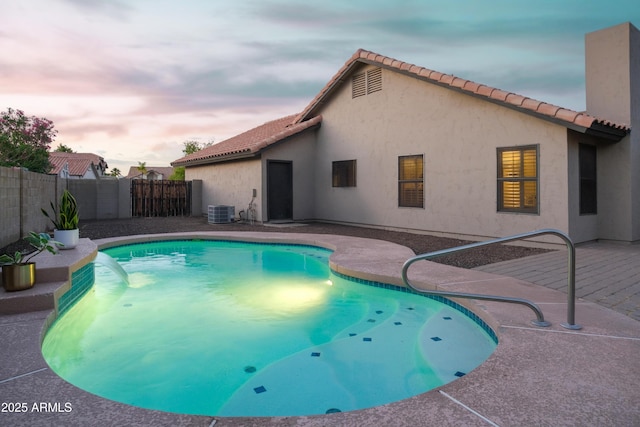 view of pool with a fenced backyard, central air condition unit, and a patio