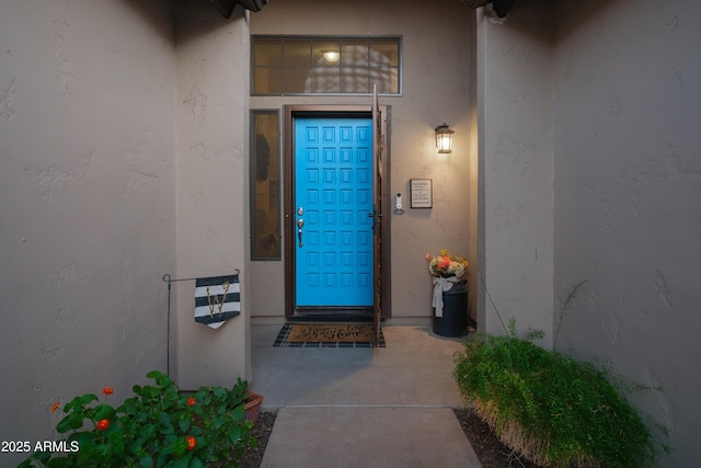 view of exterior entry featuring stucco siding