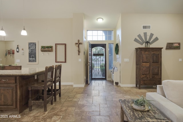 foyer entrance featuring stone tile floors and baseboards