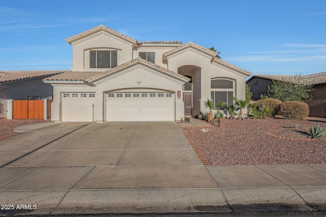 mediterranean / spanish-style house featuring driveway, a tiled roof, and stucco siding