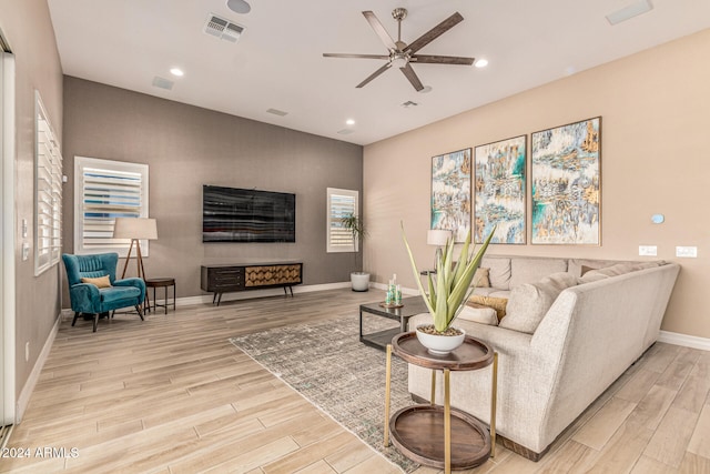 living room with ceiling fan and light hardwood / wood-style flooring