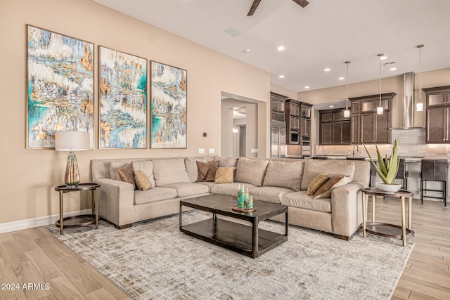 living room with ceiling fan and light hardwood / wood-style floors