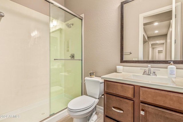 bathroom with vanity, toilet, wood-type flooring, and walk in shower