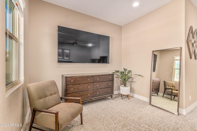 living area featuring light carpet