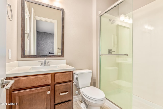 bathroom featuring an enclosed shower, vanity, toilet, and wood-type flooring