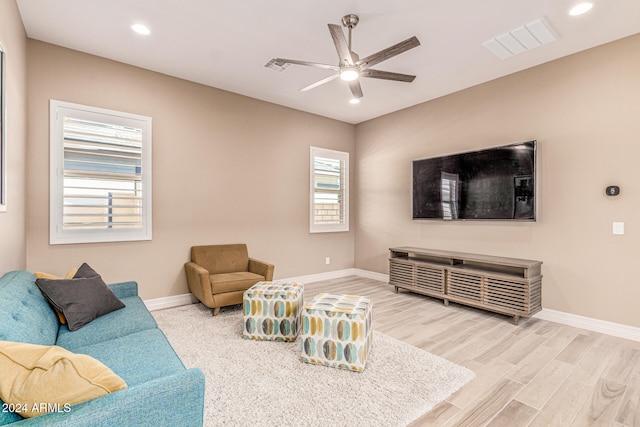 living room featuring wood-type flooring and ceiling fan