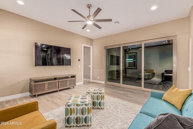 living room with light hardwood / wood-style flooring and ceiling fan