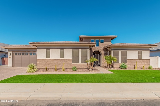 prairie-style home with a front yard and a garage