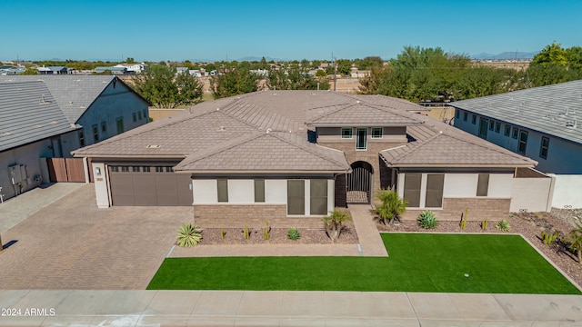 prairie-style house with a garage and a front lawn