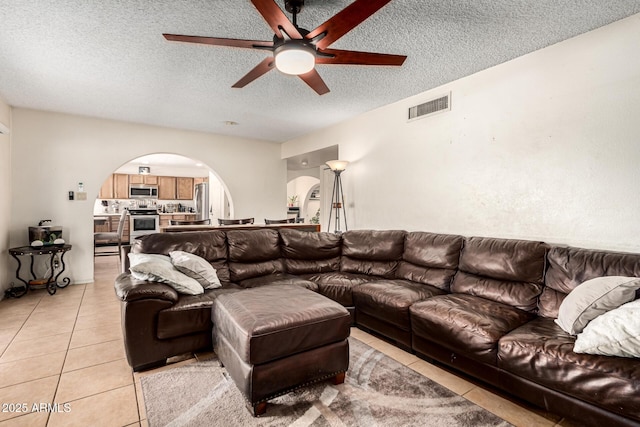 tiled living room featuring ceiling fan and a textured ceiling