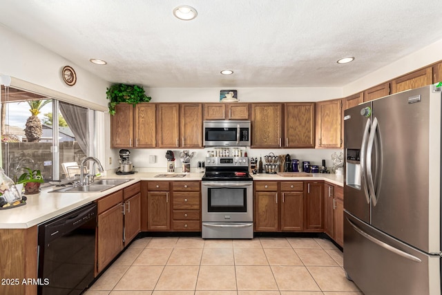 kitchen featuring appliances with stainless steel finishes, sink, a textured ceiling, and light tile patterned floors