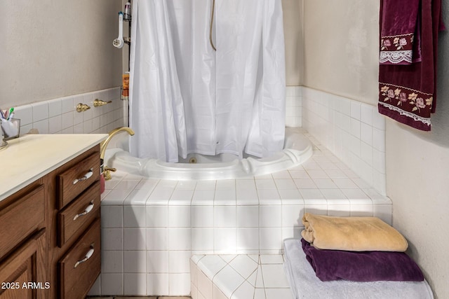 bathroom with vanity and tiled tub