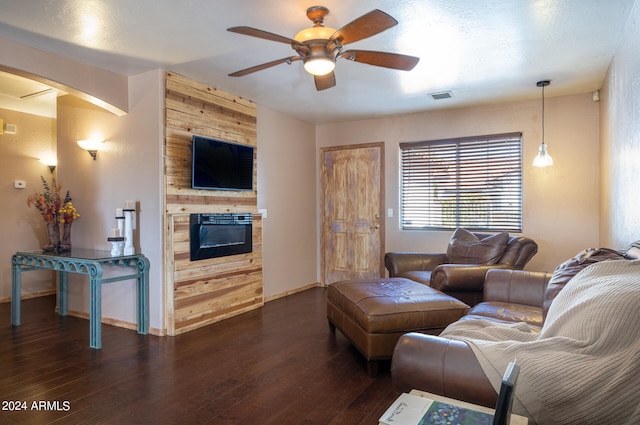 living room with wood walls, dark hardwood / wood-style floors, and ceiling fan