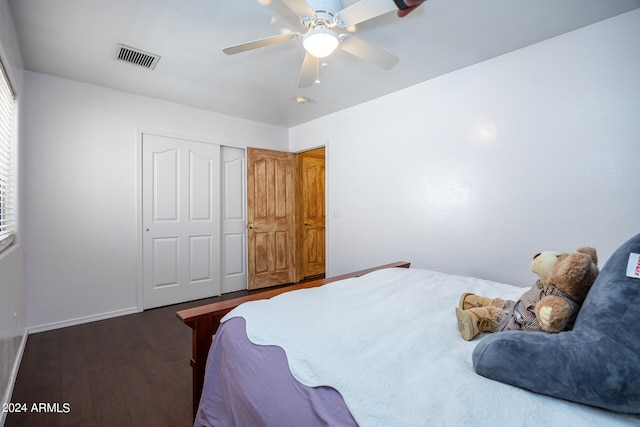 bedroom featuring ceiling fan, a closet, and dark wood-type flooring