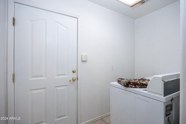 laundry area with washer / clothes dryer and light tile patterned flooring