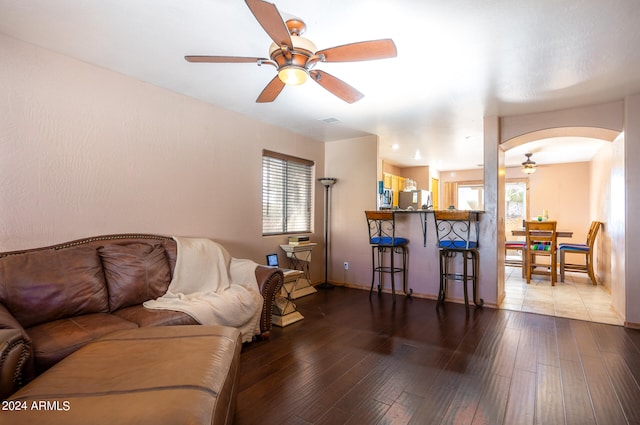 living room featuring ceiling fan, plenty of natural light, and wood-type flooring