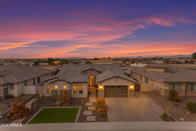 view of front of house with a residential view, a tile roof, stucco siding, decorative driveway, and an attached garage