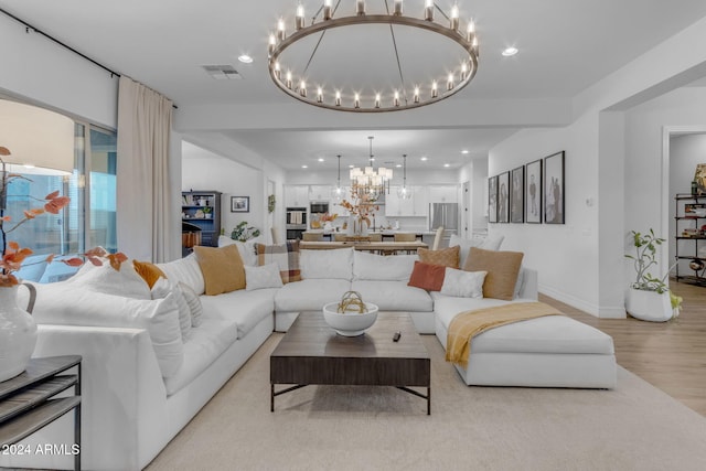 living room featuring visible vents, baseboards, an inviting chandelier, light wood-style flooring, and recessed lighting